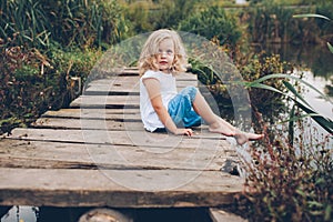 girl sitting on a wooden pier