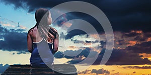 Girl sitting on wooden pier and looking in sky