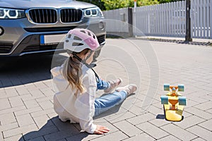 girl on skateboard was hit by car. The concept of road accidents and reduction of accidents from use of cars on the road