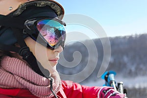 Girl in ski goggles looks away during lifting at photo