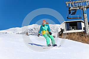 Girl in ski mask sliding on the snowboard
