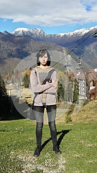 Girl at the ski resort, autumn nature, snow-capped peaks