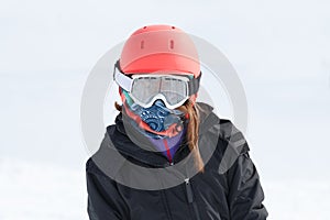 Girl skier portrait wrapped up warm in skiing gear with orange h