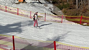 Girl skier skiing on slopes in a mountain winter ski resort slow motion
