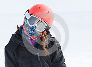 Girl skier wrapped up warm in skiing gear with helmet a