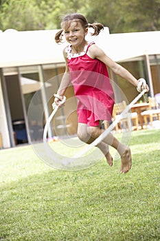 Girl Skipping In Garden