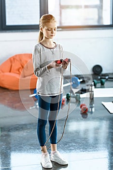 Girl with skipping rope at fitness studio