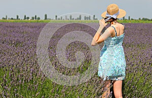 girl with skirt dress and straw hat on sunny summer day on the lavender flower field