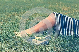 Girl in skirt lying on the green grass. The concept of rest, tranquillity and relaxation.