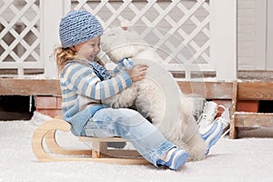 Girl on a sled with a small dog