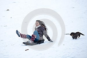 Girl sledging with her dog