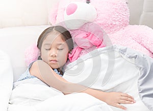 Girl sleeping with big pink teddy bear