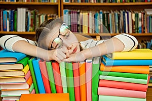 Girl sleeping on the books in the library