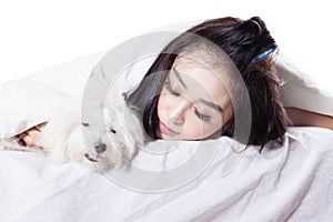 Girl sleeping with a dog under blanket