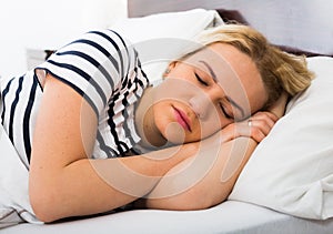 Girl sleeping with striped pygamas in bed