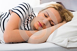 Girl sleeping with striped pygamas in bed