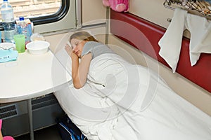 Girl sleeping in a train compartment on lower second-class place car