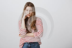 Girl almost sleeps from boredom during class. Portrait of indifferent tired female model supporting head with hand photo