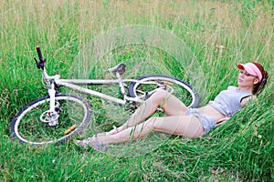 Girl with a slender figure lying on fresh green grass