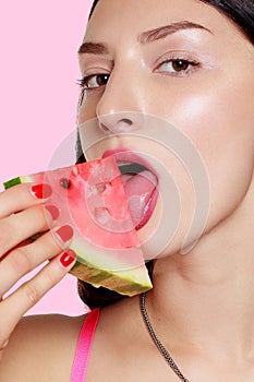 Girl with slice of watermelon on a pink background