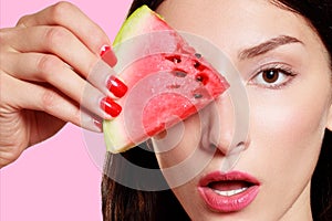 Girl with slice of watermelon on pink background