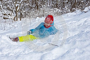 The girl slid down the hill into a snowdrift and squeezed her eyes from the snow flying into her face