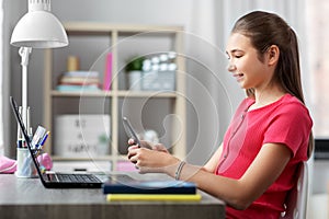 Girl with smartphone distracting from homework