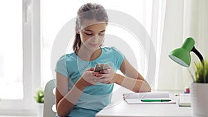 Girl with smartphone distracting from homework