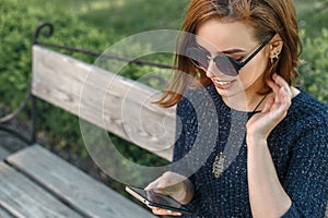 Girl with a smartphone sitting in a park