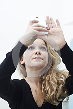 Girl with smartphone taking a photo of herself