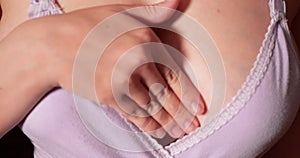 A girl smears a cream on her reddened chest. Close-up of a girl's breast suffering from mastitis or lactostasis. slow