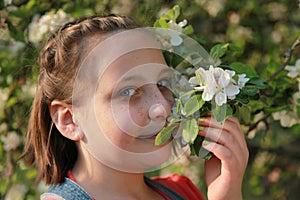 Girl smelling the blossoms of an apple tree