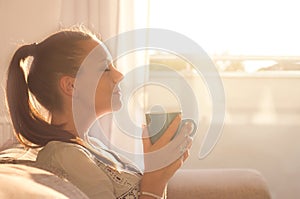 Girl smelling coffee on sunshine