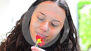 Girl smelling red flower