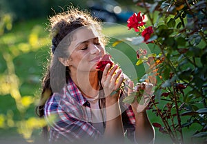 Girl smelling roses in garden