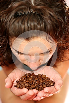 The girl smells aroma of coffee grains