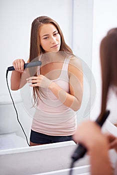 Girl, smile and bathroom to iron hair with straighter in house, care and style with tool. Happiness, woman and female