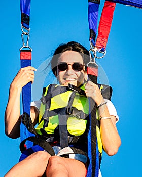Girl smile in parasail parashute mid-air. Parasailing safety and experience concept