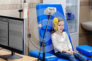 The girl smiles while doctor doing an electroencephalogram