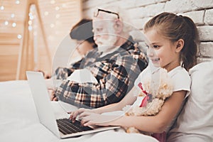 Girl smiles while playing with laptop.