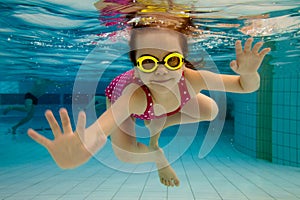 The girl smiles, swimming under