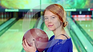 Girl smiling with bowling ball in her hands