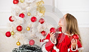 Girl smiling face hold balls ornaments white interior background. How to decorate christmas tree with kid. Let kid