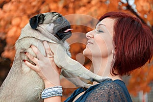 Girl smiling at her pug pet dog