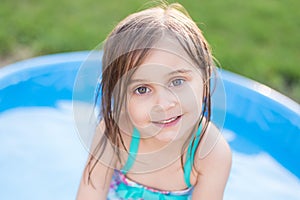 Girl smiling in kiddie pool