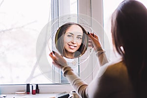 girl smiling looking in the mirror