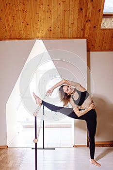 Girl smiling and looking in mirror while stretching body in fitness class