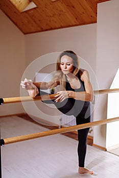 Girl smiling and looking in mirror while stretching body in fitness class