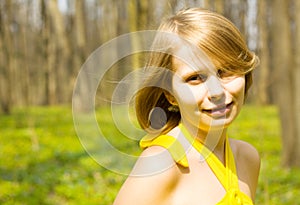Girl smiling in sunny spring field. Copy space