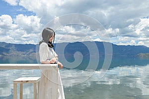 Girl smilles leaning on high table by lake bank